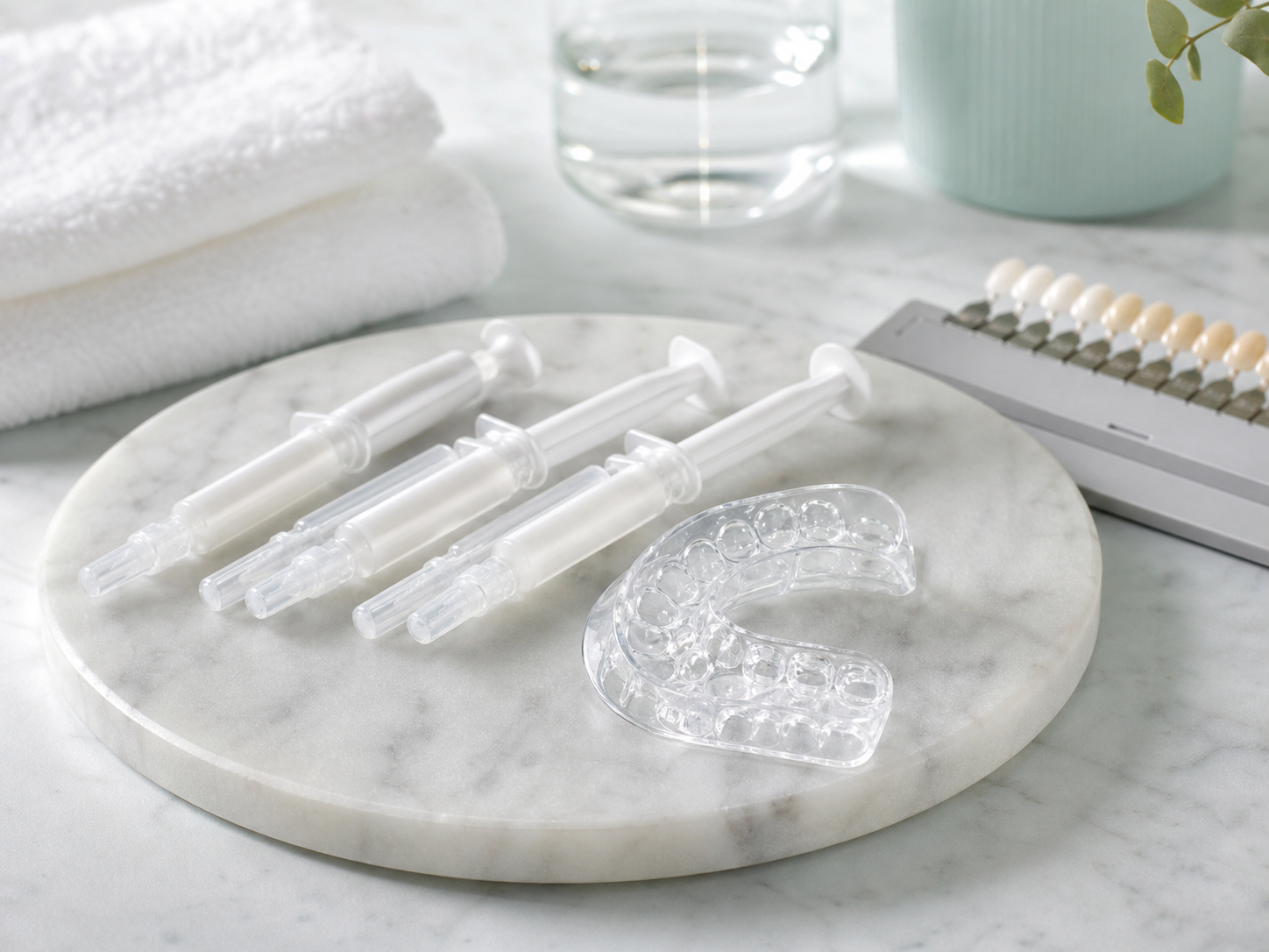 Unbranded whitening gel syringes, dental tray, and shade guide on a clean counter